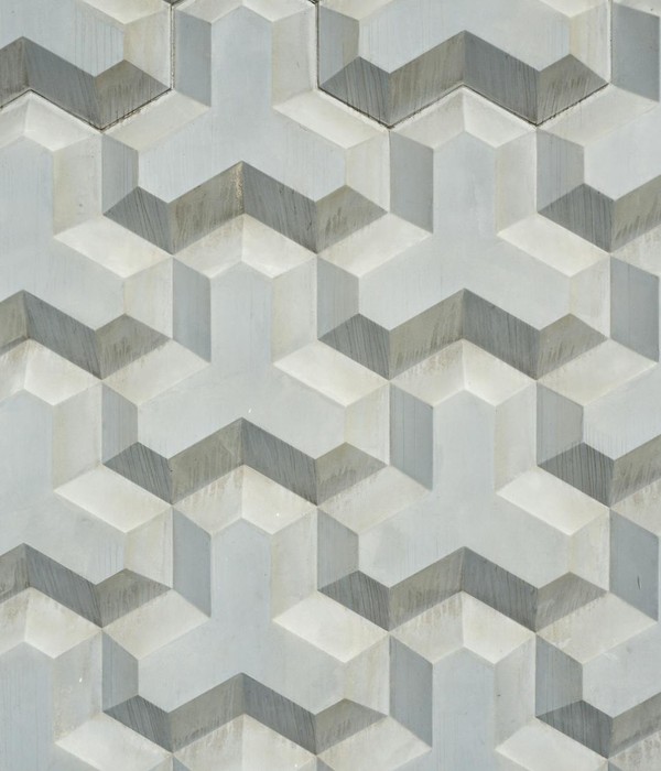 Intricate geometric pattern on a textured concrete wall, showcasing modern architecture design.